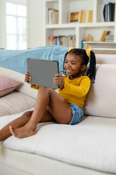 Sorrindo Menina Americana Africana Assistindo Filme Sobre Tablet Enquanto Sentado — Fotografia de Stock