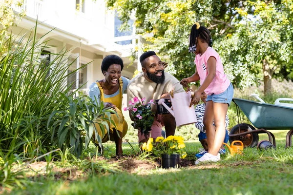 Αφροαμερικανοί Χαρούμενοι Γονείς Παιδιά Φυτεύουν Και Ποτίζουν Λουλούδια Στην Αυλή — Φωτογραφία Αρχείου
