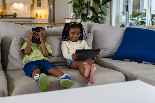 Irmã Irmão Afro Americano Usando Tablet Smartphone Enquanto Senta Sofá — Fotografia de Stock