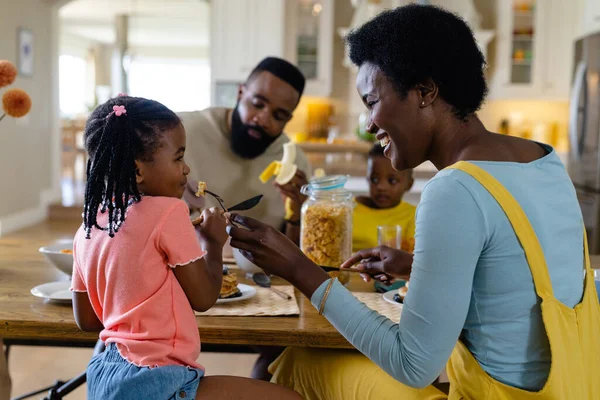 非洲裔美国母亲一边和家人一起吃早餐 一边给女儿吃煎饼 不变的生活方式 早晨和家庭观念 — 图库照片