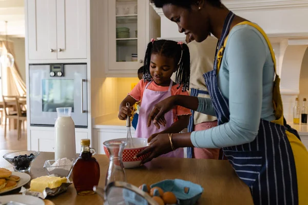 非裔美国人的母亲和女儿把面糊和威士忌混在厨房的碗里 不变的生活方式 准备和学习概念 — 图库照片