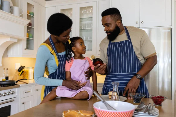 非裔美国人的父母和女儿在厨房柜台上做煎饼 不变的生活方式 准备和学习 — 图库照片