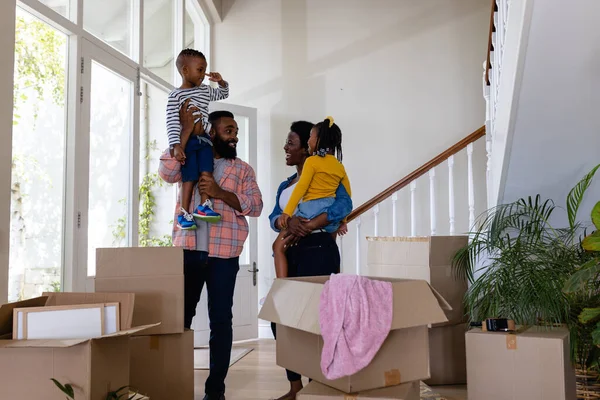 非洲裔美国父母背着孩子站在新家里的纸板箱旁 搬家和搬迁概念 — 图库照片