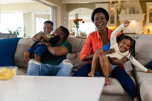 非洲裔美国人快乐的父母和孩子坐在客厅的沙发上看电视 不变的生活方式 放松和家庭观念 — 图库照片