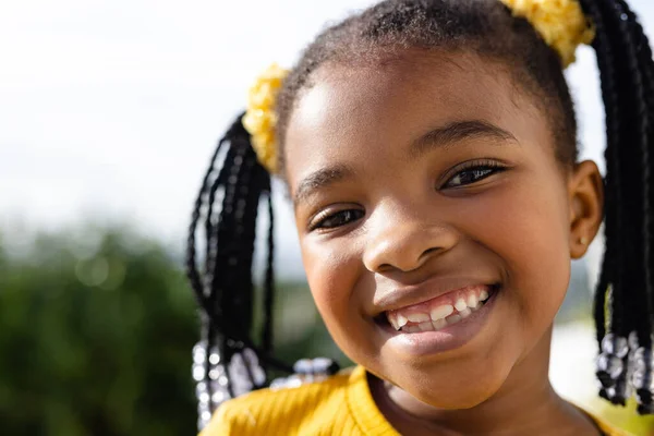 庭の澄んだ空に向かってカメラで微笑むかわいいアフリカ系アメリカ人の少女のクローズアップ肖像画 変更されず 子供時代 幸せとライフスタイルの概念 — ストック写真