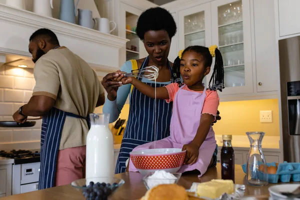 非裔美国人的母亲和女儿把面糊和威士忌混在厨房的碗里 不变的生活方式 准备和学习 — 图库照片