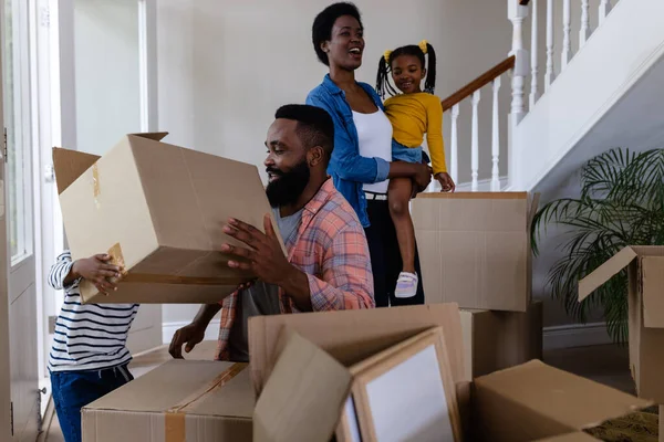 非裔美国人的父母和孩子在新家里安排纸板箱 搬家和搬迁概念 — 图库照片