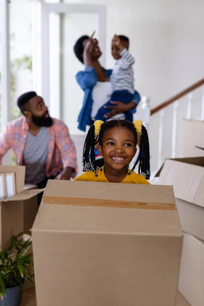 アフリカ系アメリカ人の娘と父親の笑顔が新しい家で家族と一緒に箱を運んでいます 変更されていない 子供時代 引っ越しの家と移転の概念 — ストック写真