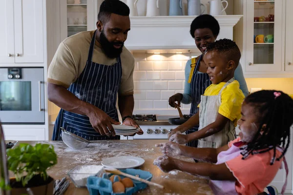 Africké Americké Děti Hrají Moukou Zatímco Rodiče Dělají Palačinky Kuchyni — Stock fotografie