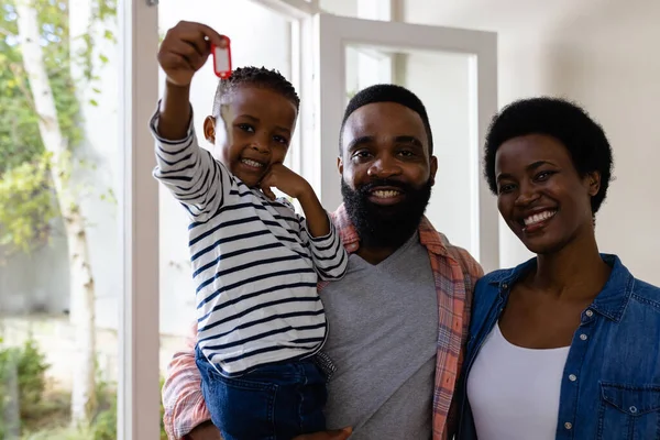新しい家の鍵を握って息子を運ぶアフリカ系アメリカ人の両親の笑顔の肖像画 変更されていない 子供時代 引っ越しの家と移転の概念 — ストック写真