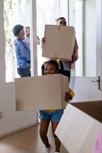 アフリカ系アメリカ人の父と娘が新しい家に入りながら段ボール箱を持っている 変更されていない 子供時代 引っ越しの家と移転の概念 — ストック写真