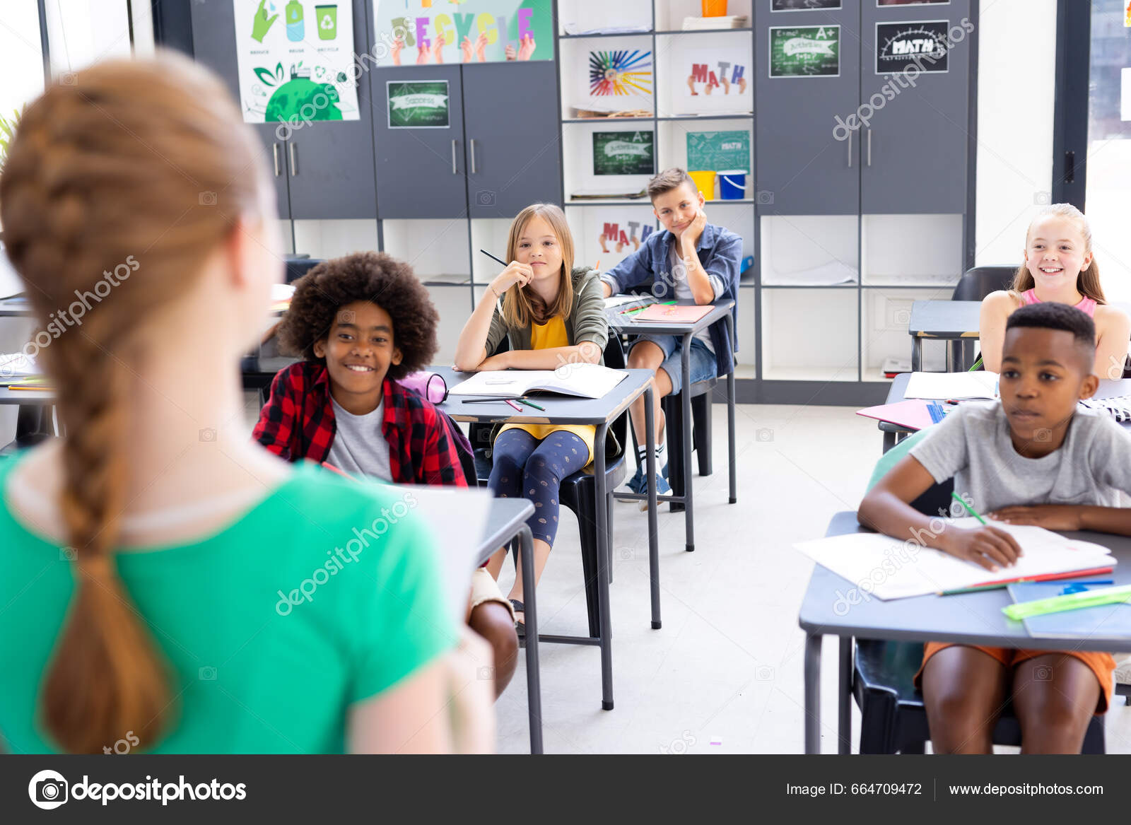 Diverse Elever Som Sitter Skrivebordet Hører Skolejenta Som Leser Til –  stockfoto © Wavebreakmedia #664709472, image size:1600x1167