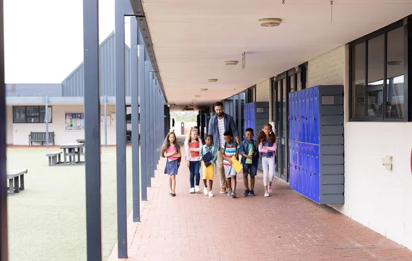 Diverse Happy Male Teacher Elementary Schoolchildren Walking School Corridor Copy — Stock Photo, Image