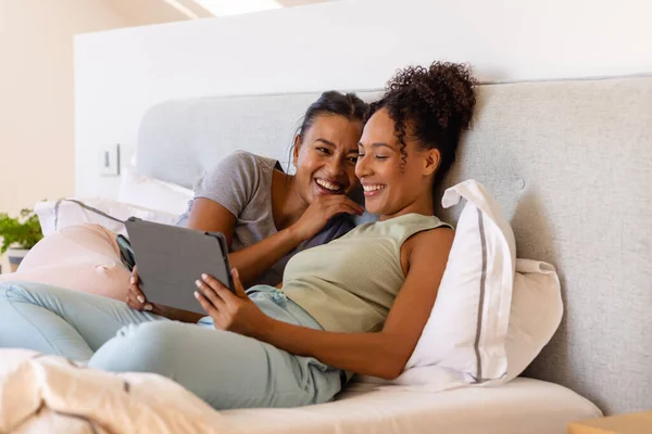 快乐的一对同性恋夫妇在床上用平板电脑在卧室里 生活方式 沟通和家庭生活 — 图库照片