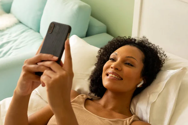 快乐的女人 带着耳机 用智能手机躺在床上 生活方式 交流和家庭生活 — 图库照片