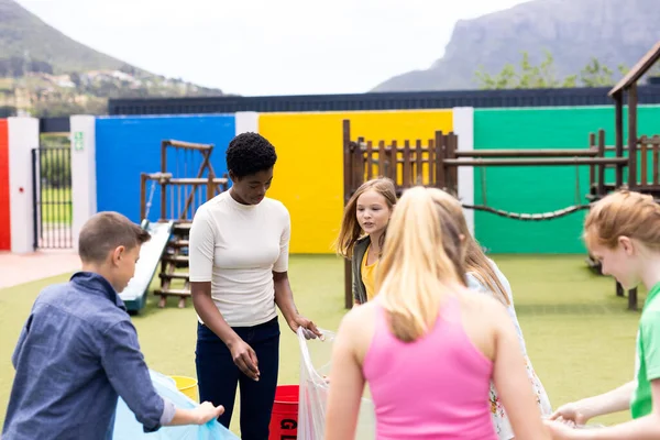 Diverse Female Teacher Pupils Collecting Rubbish Recycling Schoolyard Copy Space — Stock Photo, Image