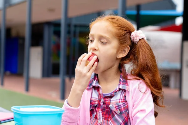 Biracial Schoolgirl Sitting Table Schoolyard Eating Apple Education Childhood Elementary — Stock Photo, Image