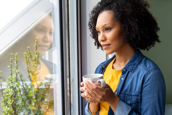 Счастливая Расовая Женщина Держит Чашку Кофе Смотрит Окно Дома Релаксация — стоковое фото