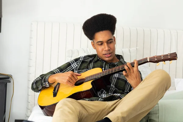 Feliz Hombre Biracial Sentado Cama Tocando Guitarra Casa Música Estilo —  Fotos de Stock