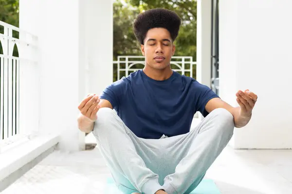 Avslappnad Biracial Man Praktiserar Yoga Meditation Sittande Balkong Lotus Position — Stockfoto