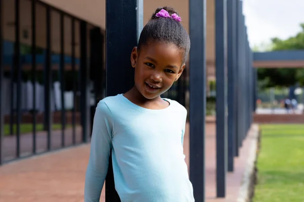 Portrait Happy Biracial Schoolgirl Smiling Leaning Post Schoolyard Education Inclusivity — Stock Photo, Image