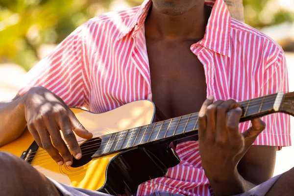 坐在阳光明媚的海滩上弹奏吉他手的中间段 生活方式 夏天和假期 — 图库照片