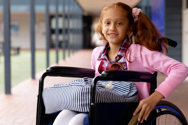 坐在轮椅上的快乐的出生女学生的画像 在学校走廊里微笑 包容性和学习概念 — 图库照片