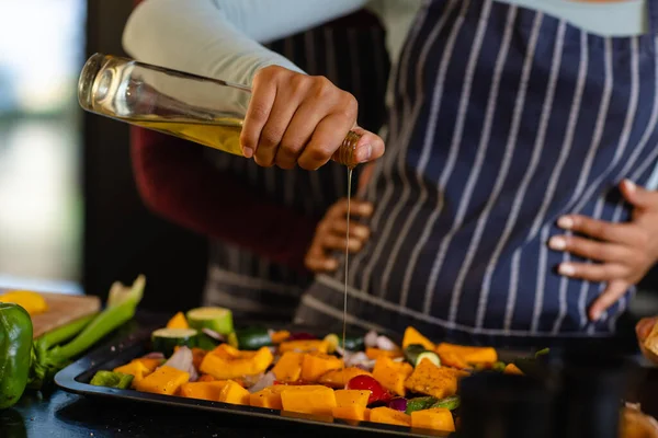 Mid Section Biracial Lesbian Couple Embracing Pouring Oil Vegetables Kitchen — Stock Photo, Image