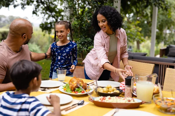 가족의 부모들 과딸은 음식을 제공하고 테라스에서 식사를 식탁에 앉는다 어울리고 — 스톡 사진