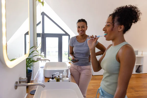 Feliz Pareja Lesbianas Birraciales Cepillarse Los Dientes Uso Smartphone Baño — Foto de Stock