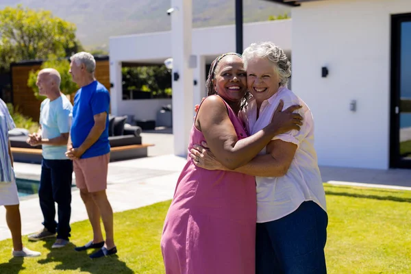 幸せな高齢者の多様な人々のグループを受け入れ 庭で笑顔 シニアライフスタイル 友情とリラクゼーション 変わらない — ストック写真