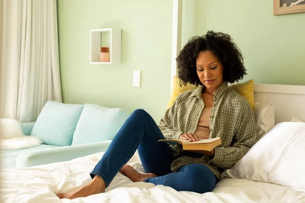 明るい寝室でベッドの上で本を読んでいる出産の女性 リラックス ライフスタイルと国内生活 変更なし — ストック写真