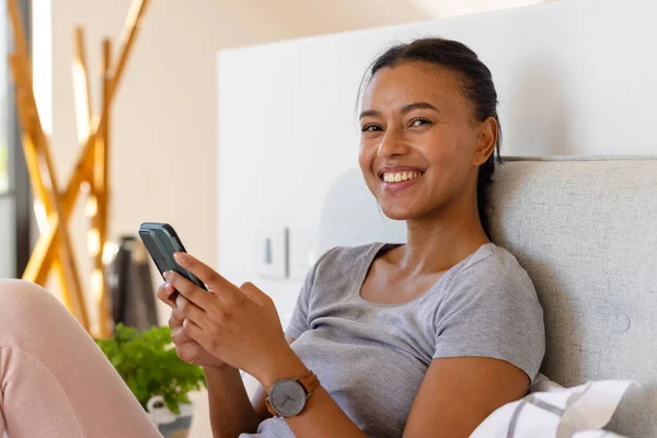 快乐的女人在床上用智能手机在卧室里 生活方式 交流和家庭生活 — 图库照片
