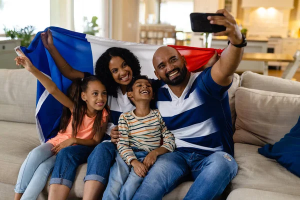 幸福的父母坐在沙发上 举着法国国旗 自私自利 面带微笑 爱国主义 生活方式和家庭生活 — 图库照片