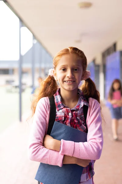 小学校の廊下で笑顔の女の子の垂直な肖像画 コピースペース コミュニティ 小学校 学習コンセプト — ストック写真