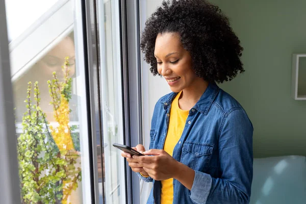 Щаслива Жінка Використовує Смартфон Вікном Вдома Спосіб Життя Спілкування Побутове — стокове фото