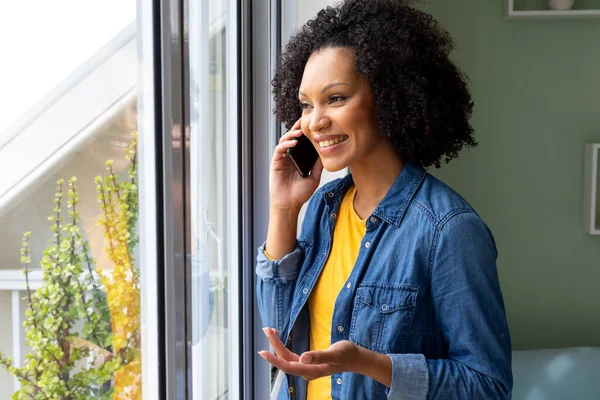 幸せな出産の女性はスマートフォンで話し 家で窓の外を見る ライフスタイル コミュニケーション 国内生活変更なし — ストック写真