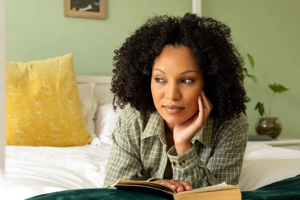 ベッドの上に寝そべって本を読んでいる生粋の女性 リラックス ライフスタイルと国内生活 変更なし — ストック写真