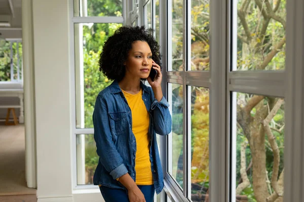 Biracial Woman Talking Smartphone Looking Out Window Home Lifestyle Communication — Stock Photo, Image
