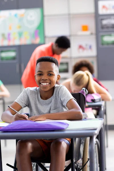 Függőleges Portré Egy Mosolygó Afro Amerikai Iskolásról Tolószékben Íróasztalnál Osztályban — Stock Fotó