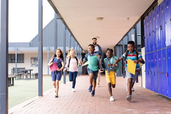 Mutlu Çocuklu Erkek Öğretmen Ilkokul Koridorunda Koşuyor Kopyalama Alanı Eğitim — Stok fotoğraf