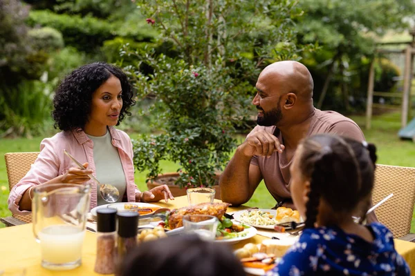 快乐的父母 儿子和女儿坐在餐桌边吃饭 在花园里聊天 食物和生活方式 — 图库照片