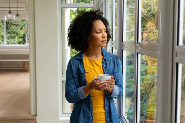 Biracial Woman Holding Cup Coffee Looking Out Window Home Relaxation — Stock Photo, Image