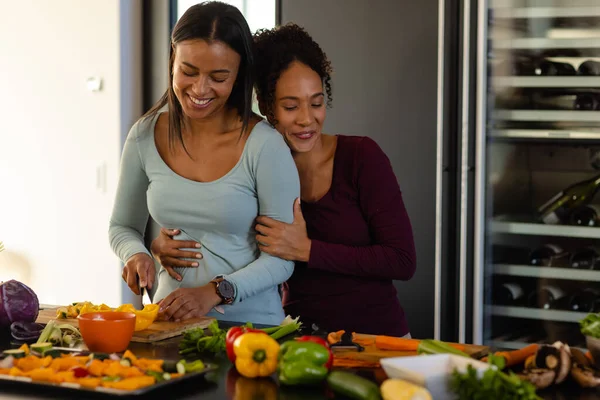 Happy Biracial Lesbian Couple Embracing Chopping Vegetables Kitchen Cooking Food — Stock Photo, Image