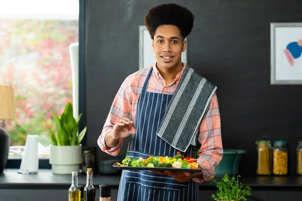 台所でみじん切り野菜のベーキングトレイを保持食事を準備幸せな出生男の肖像画 健康的なライフスタイルと国内生活 変更なし — ストック写真