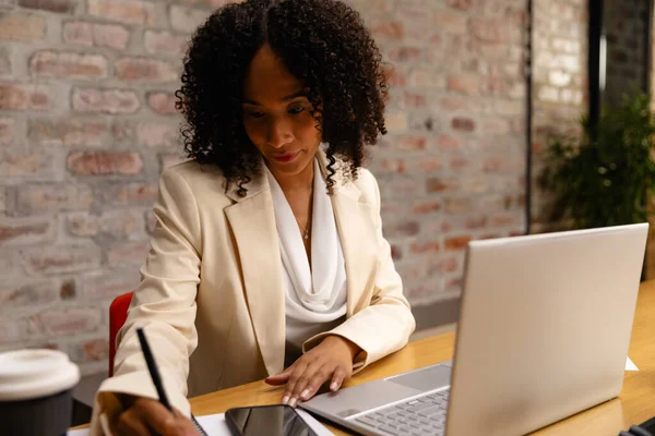 非洲裔美国女商人使用笔记本电脑并在办公室做笔记 临时办公室 通信和工作 未经改动 — 图库照片