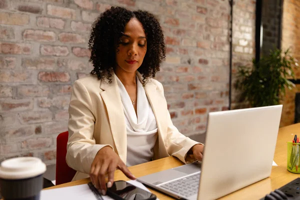 Ofiste Dizüstü Bilgisayar Akıllı Telefon Kullanan Afro Amerikan Bir Kadını — Stok fotoğraf