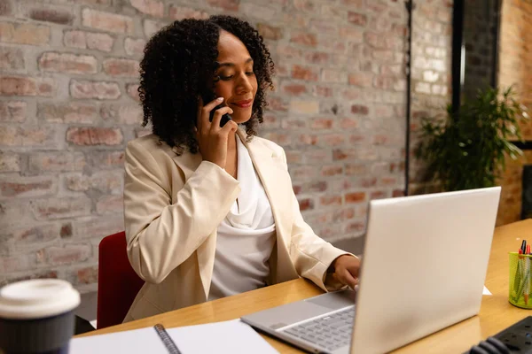 African American Casual Businesswoman Using Laptop Talking Smartphone Office Casual — Stock Photo, Image