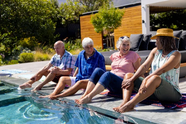プールに座って庭で笑顔の幸せなシニア多様な人々 シニアライフスタイル 友情とリラクゼーション 変わらない — ストック写真