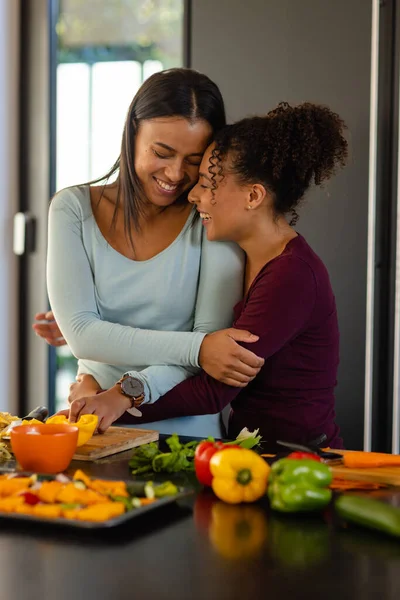Happy Biracial Lesbian Couple Hugging Chopping Vegetables Kitchen Cooking Food — Stock Photo, Image